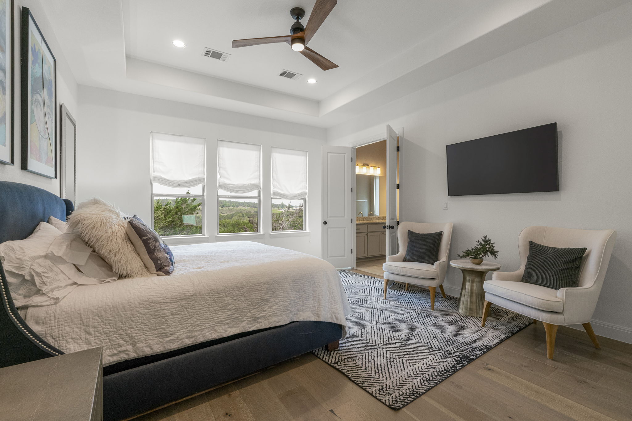 288 Hazy Hills Loop Dripping Springs, TX 78620 - Photo 8 of 40 The primary suite offers a calm, private setting with elevated lighting, tray ceilings, and views of the protected greenbelt.
