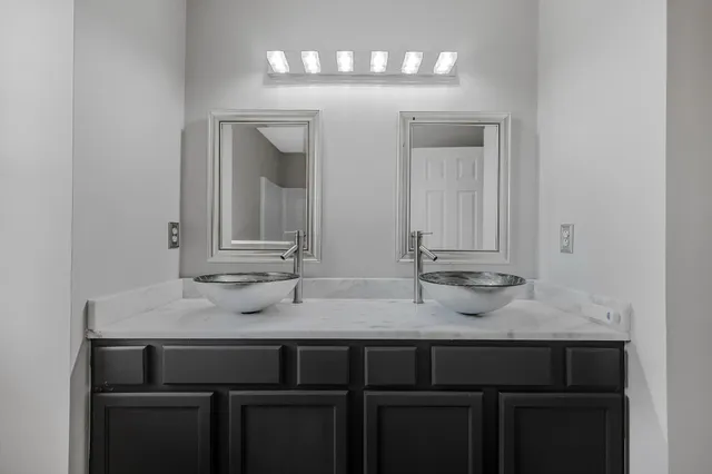 a bathroom with double vanity sinks and a mirror