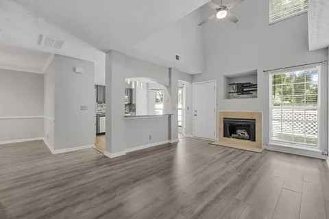 a view of a livingroom with wooden floor a fireplace and window