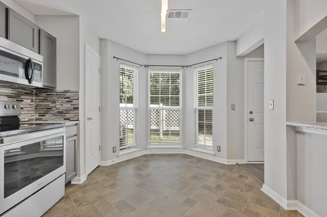 a view of an empty room with a fireplace and a window