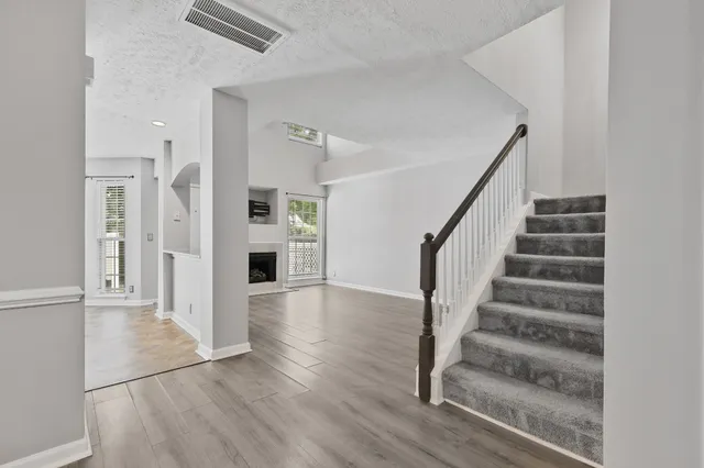 a view of entryway with wooden floor and kitchen view