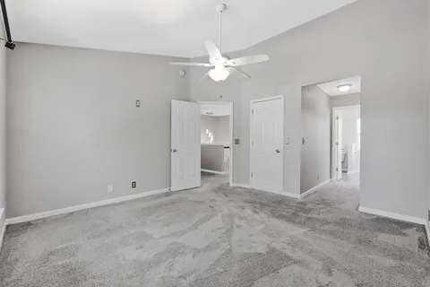 an empty room with fan and entrance