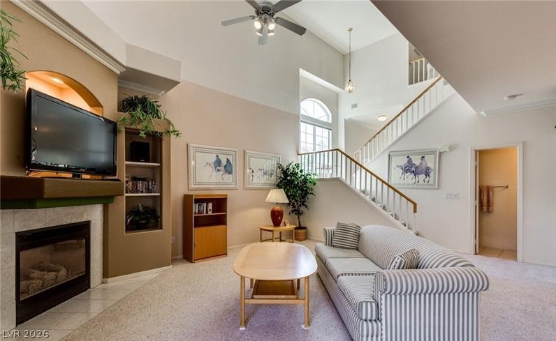 5272 Island Chain Road Las Vegas, NV 89118 - Photo 28 of 31 A striking two-story living area features a cozy fireplace, high ceilings, and a graceful staircase leading to the upper level.