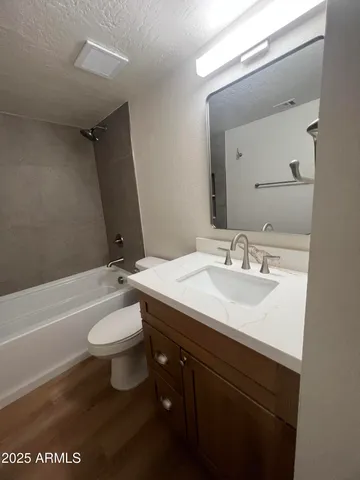 a bathroom with a sink a toilet a mirror and bathtub