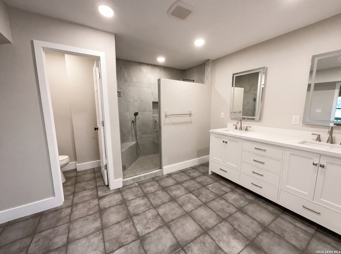 15422 Geronimo Loop San Antonio, TX 78254 - Photo 6 of 21 a bathroom with a double vanity sink mirror and shower