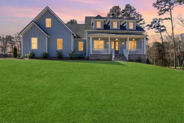 a view of a big house with a big yard and large trees