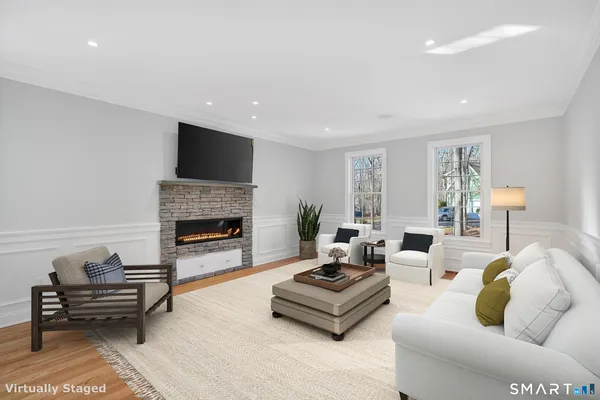 a living room with furniture a flat screen tv and a fireplace