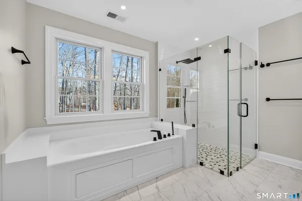 a bathroom with a sink and a mirror with shower