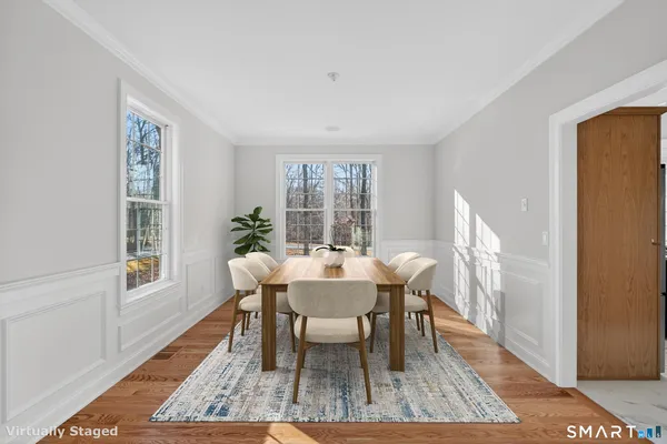 a dining room with furniture a rug and wooden floor