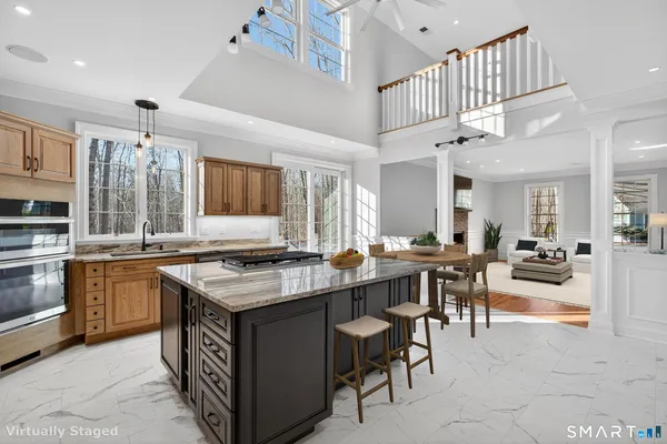 a kitchen with stainless steel appliances granite countertop a stove a sink a dining table and chairs