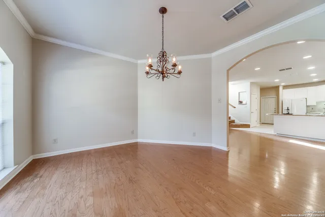 a view of a room with wooden floor and a chandelier