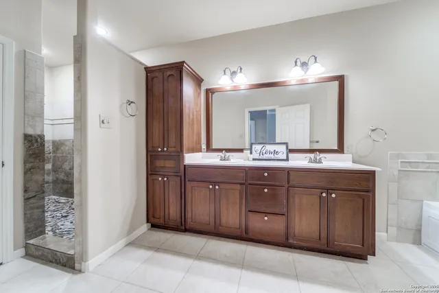 a bathroom with a vanity a sink a large mirror and a shower