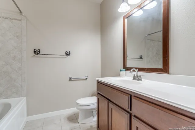 a bathroom with a granite countertop sink a toilet and a mirror