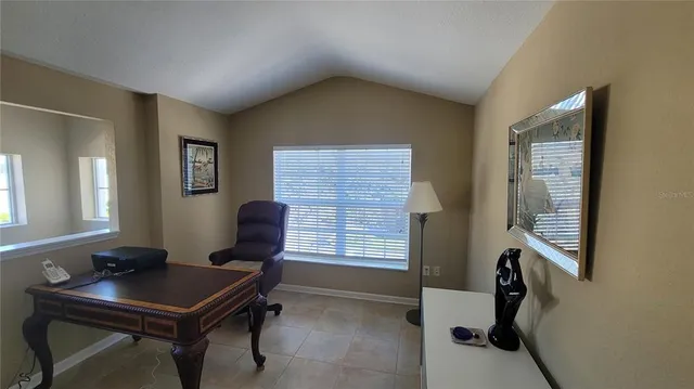 a view of a workspace with furniture and a window