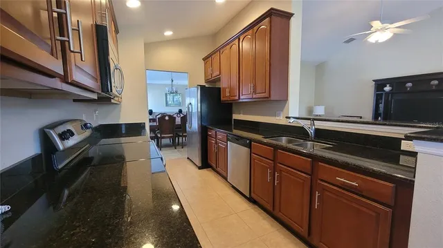 a kitchen with stainless steel appliances granite countertop a sink stove and refrigerator