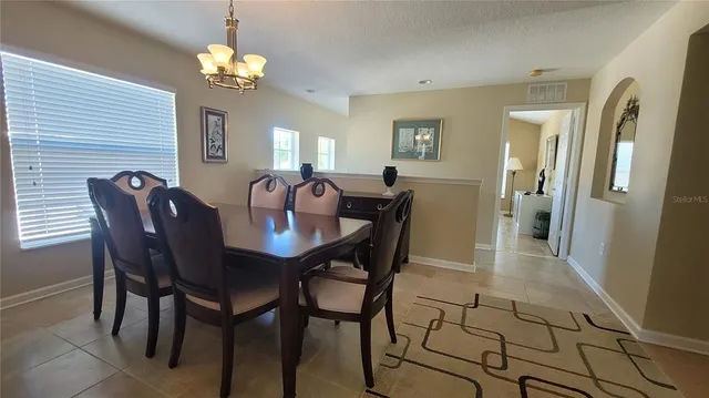 a view of a dining room with furniture and chandelier