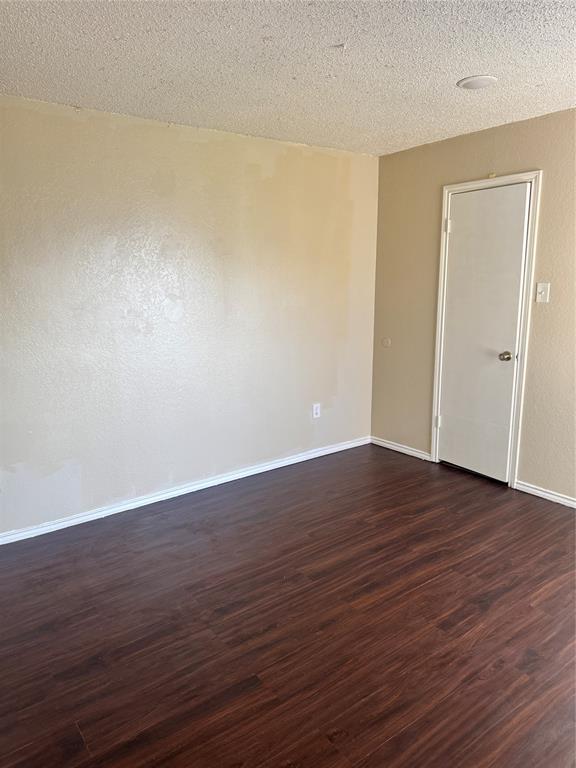 5617 Mansfield Road Arlington, TX 76017 - Photo 8 of 15 2nd Bedroom featuring wood-finish flooring, neutral wall paint, white baseboards, and a white interior door with a silver-tone knob