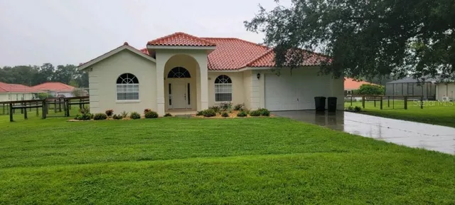 a front view of a house with a garden and yard