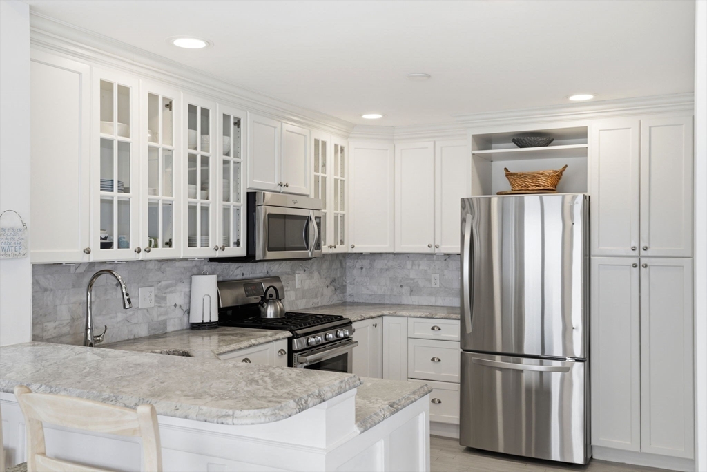 60 Holbrook Avenue Hull, MA 02045 - Photo 13 of 37 a kitchen with stainless steel appliances granite countertop a refrigerator a stove a sink and a granite counter tops with wooden floors