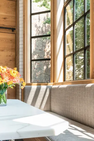 a kitchen with a stove a sink dishwasher and a dining table with wooden floor