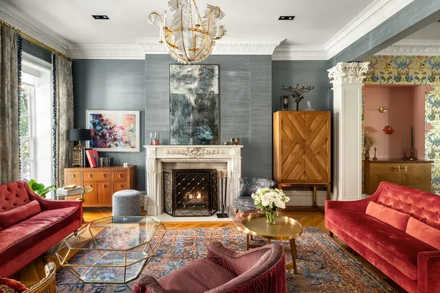 a living room with furniture a fireplace and a chandelier