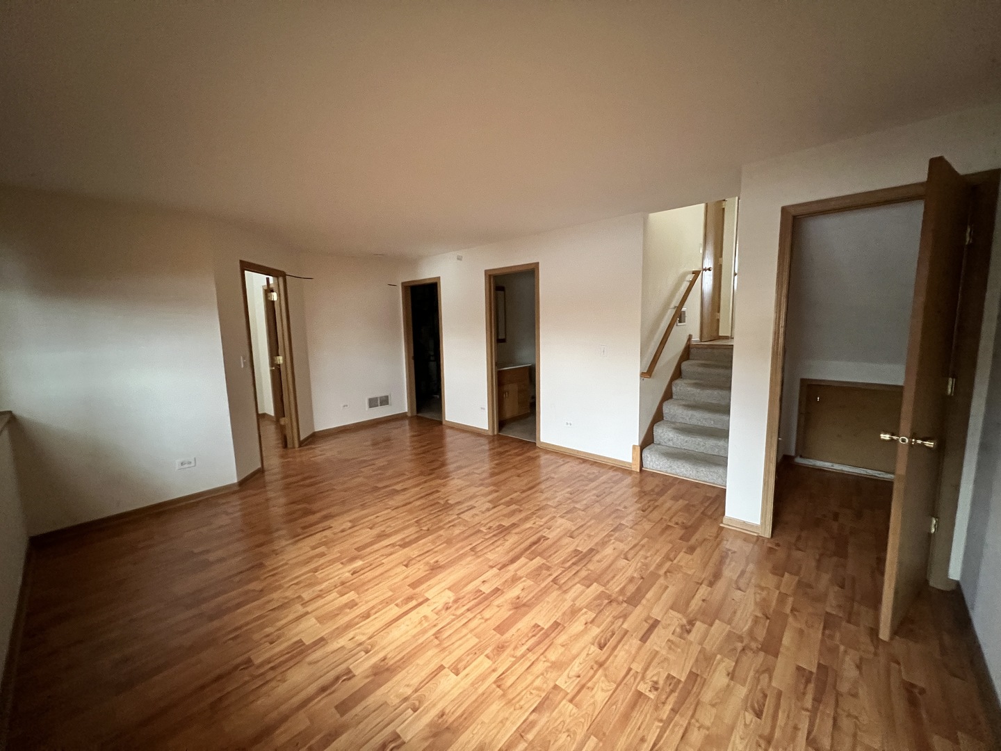 8256 Chestnut Court Frankfort, IL 60423 - Photo 17 of 22 a view of an empty room with wooden floor and stairs