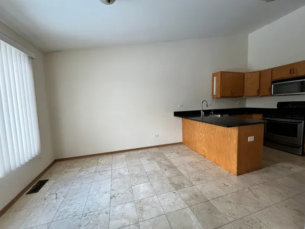 a kitchen with granite countertop a sink a stove top oven and a window