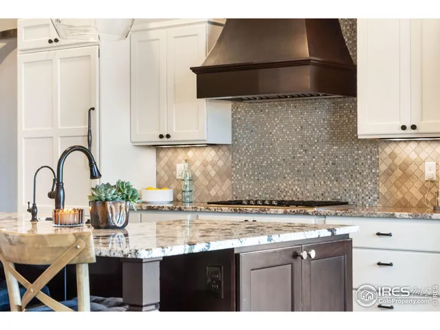 a kitchen with kitchen island granite countertop a table chairs sink and cabinets