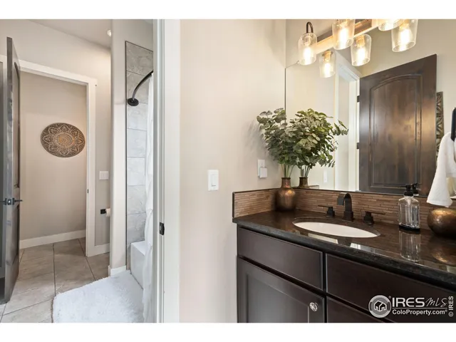 a bathroom with a granite countertop sink and a large mirror