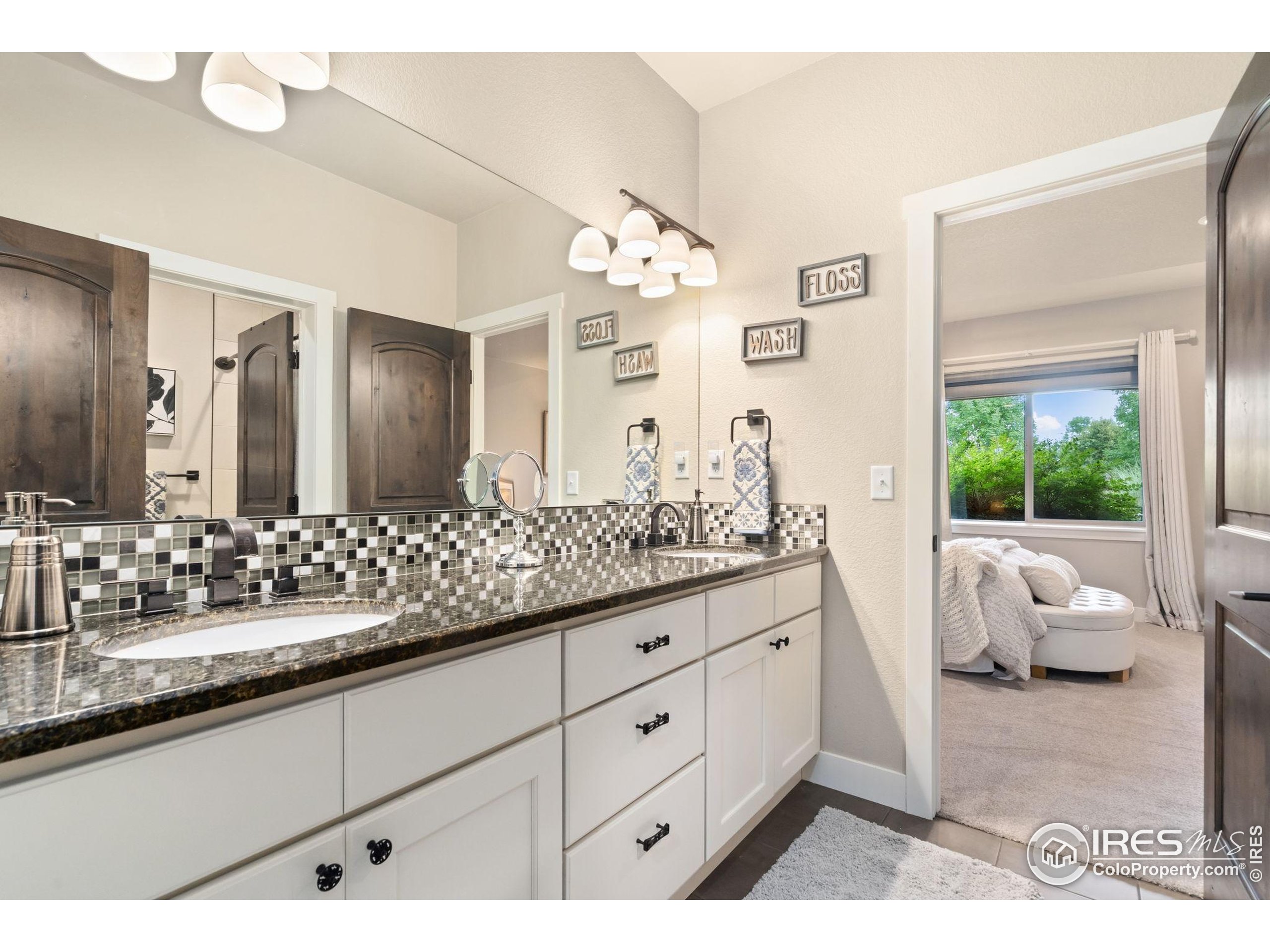 3828 Valley Crest Drive Timnath, CO 80547 - Photo 31 of 50 a bathroom with a granite countertop sink and a large mirror