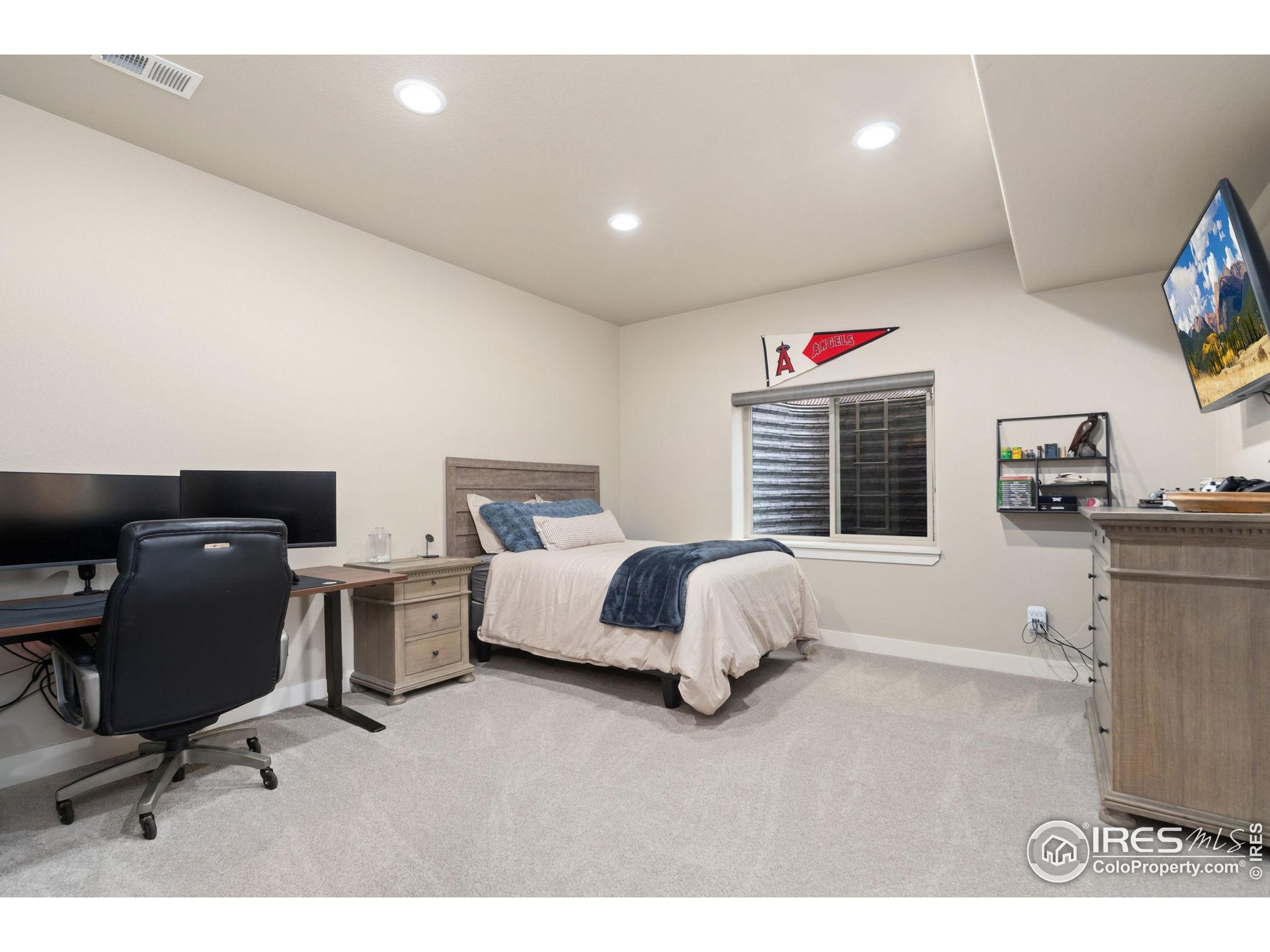 3828 Valley Crest Drive Timnath, CO 80547 - Photo 32 of 50 a spacious bedroom with a bed and a desk