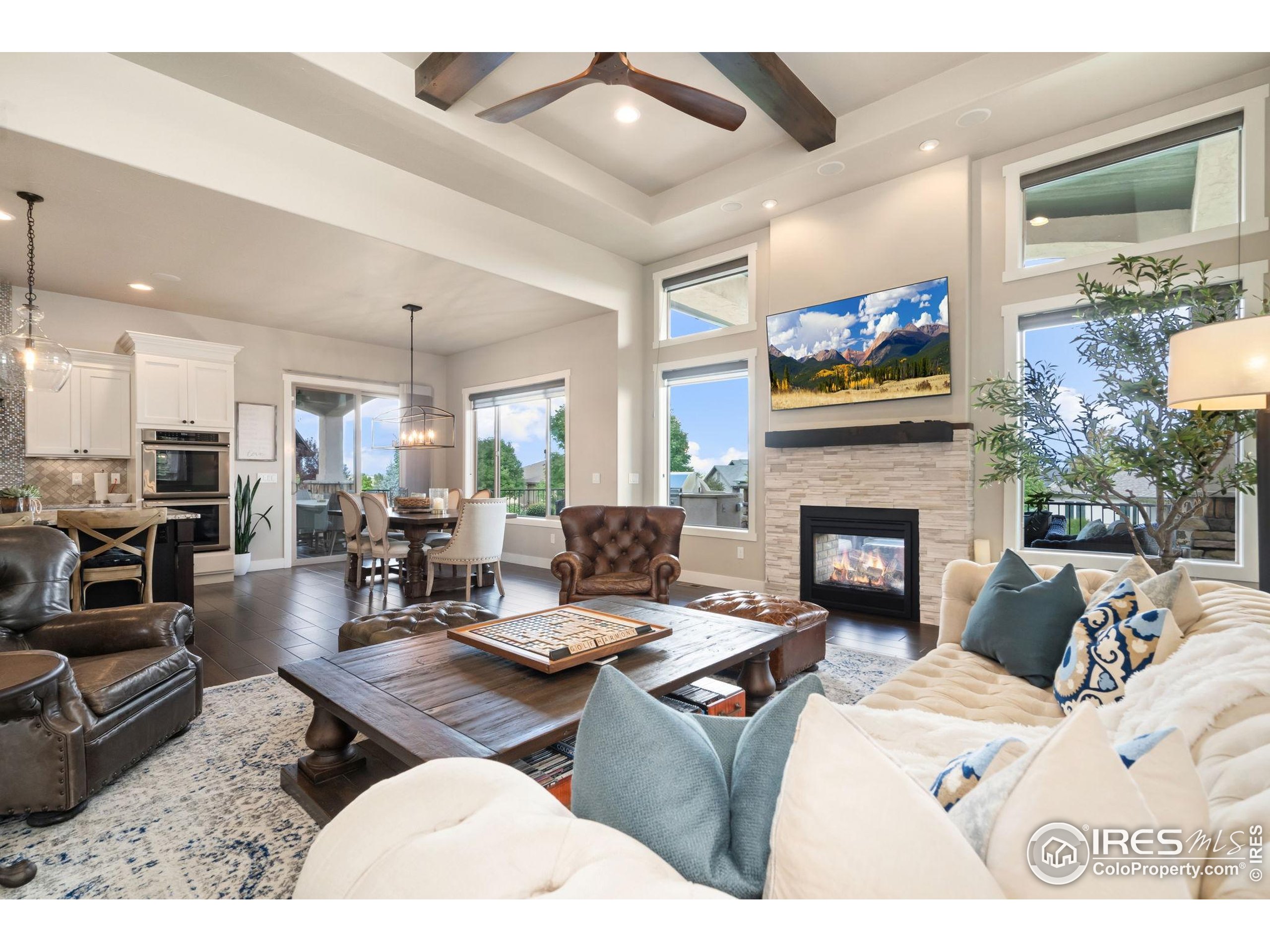 3828 Valley Crest Drive Timnath, CO 80547 - Photo 6 of 50 a living room with furniture a fireplace and a flat screen tv