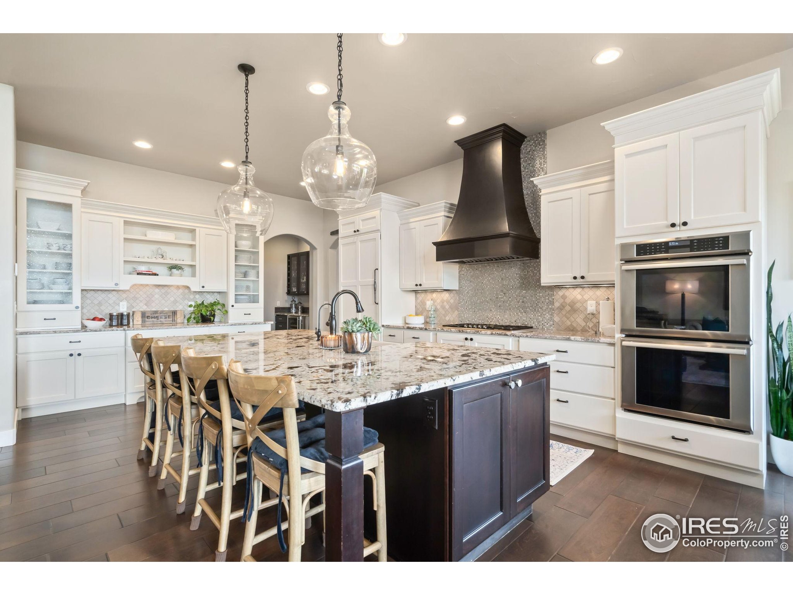 3828 Valley Crest Drive Timnath, CO 80547 - Photo 8 of 50 a kitchen with stainless steel appliances kitchen island granite countertop a stove a sink and a microwave