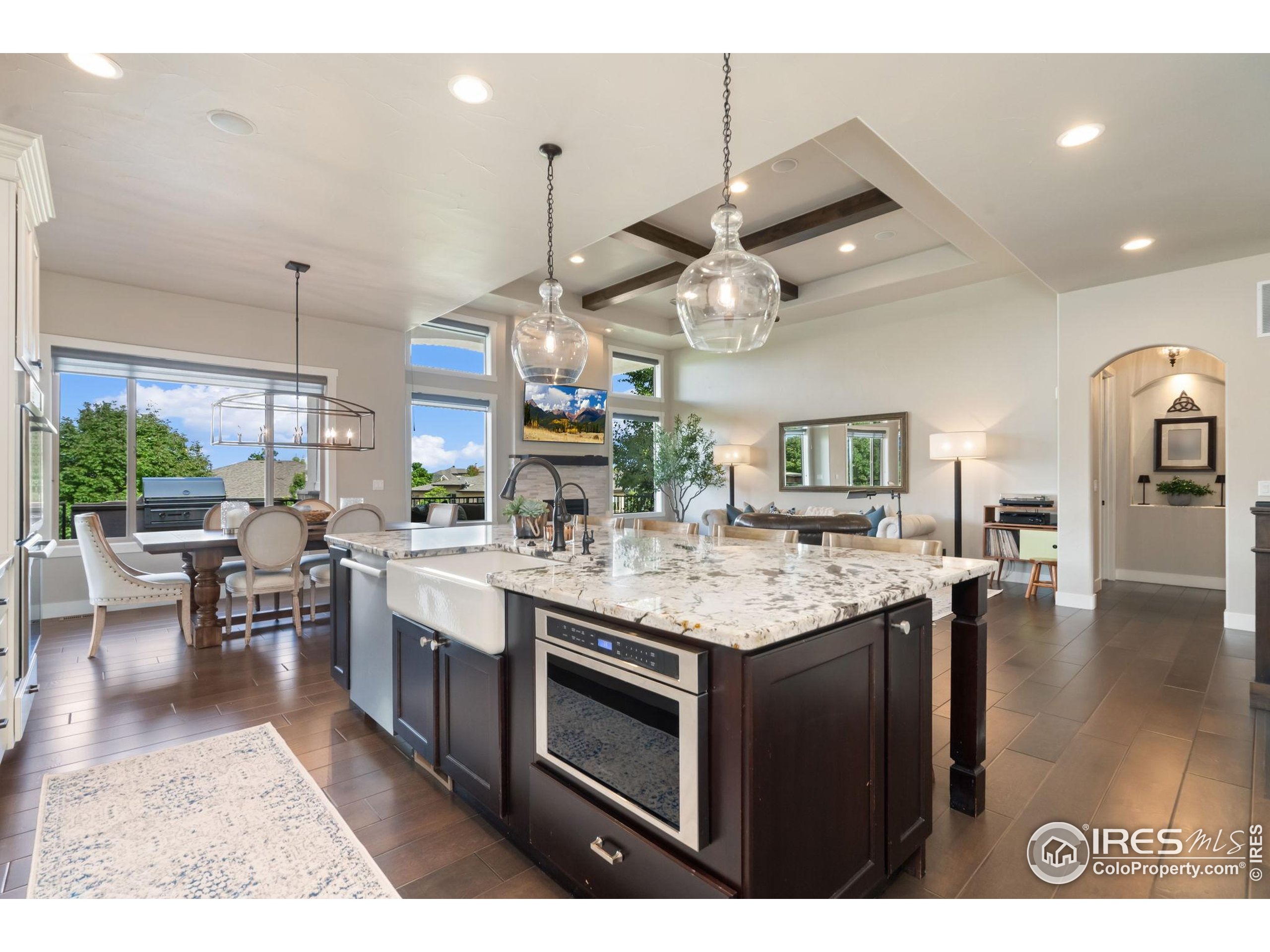 3828 Valley Crest Drive Timnath, CO 80547 - Photo 9 of 50 a kitchen with a stove a counter space dining table and chairs