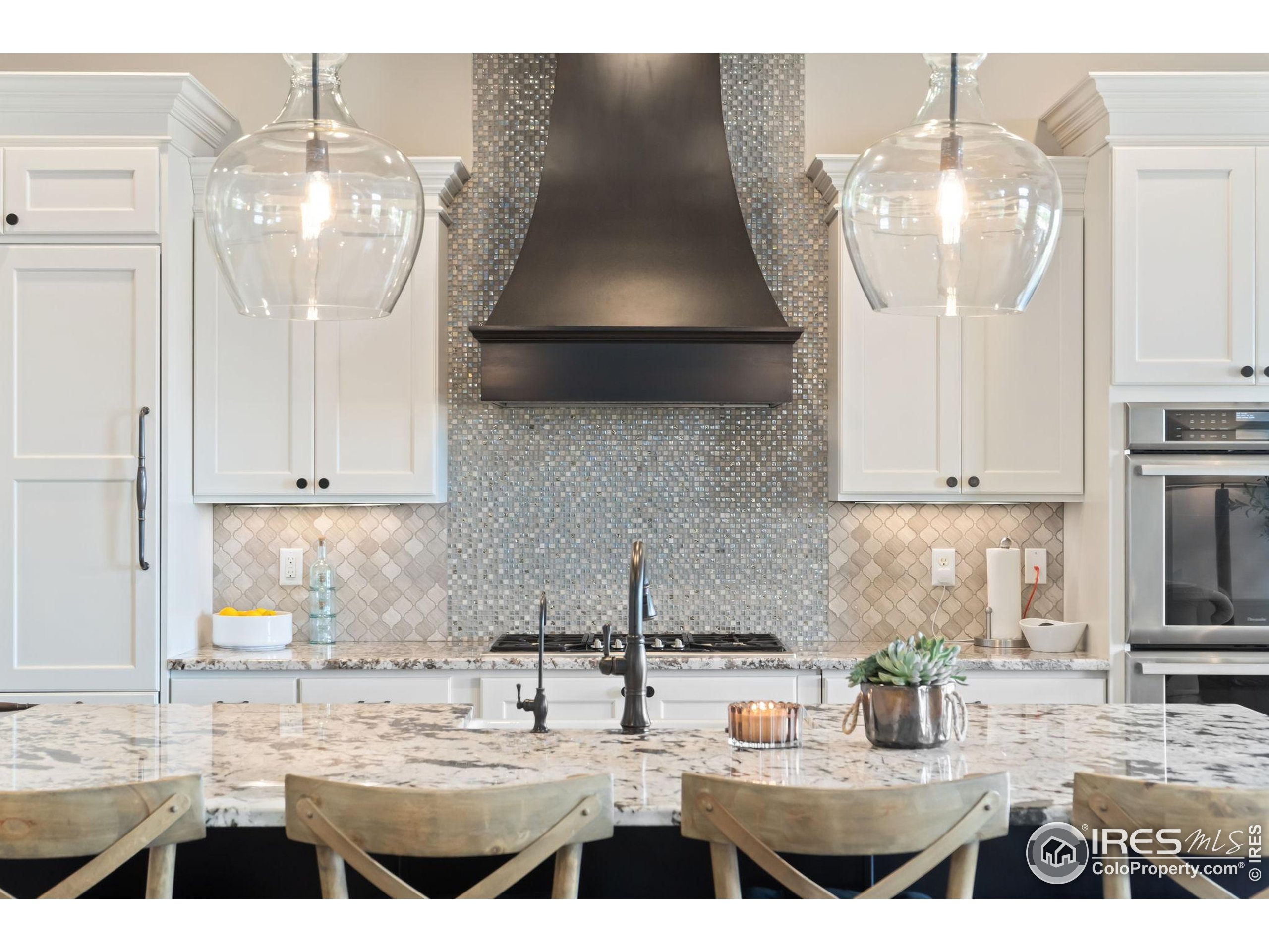 3828 Valley Crest Drive Timnath, CO 80547 - Photo 10 of 50 a kitchen with a sink a stove and white cabinets