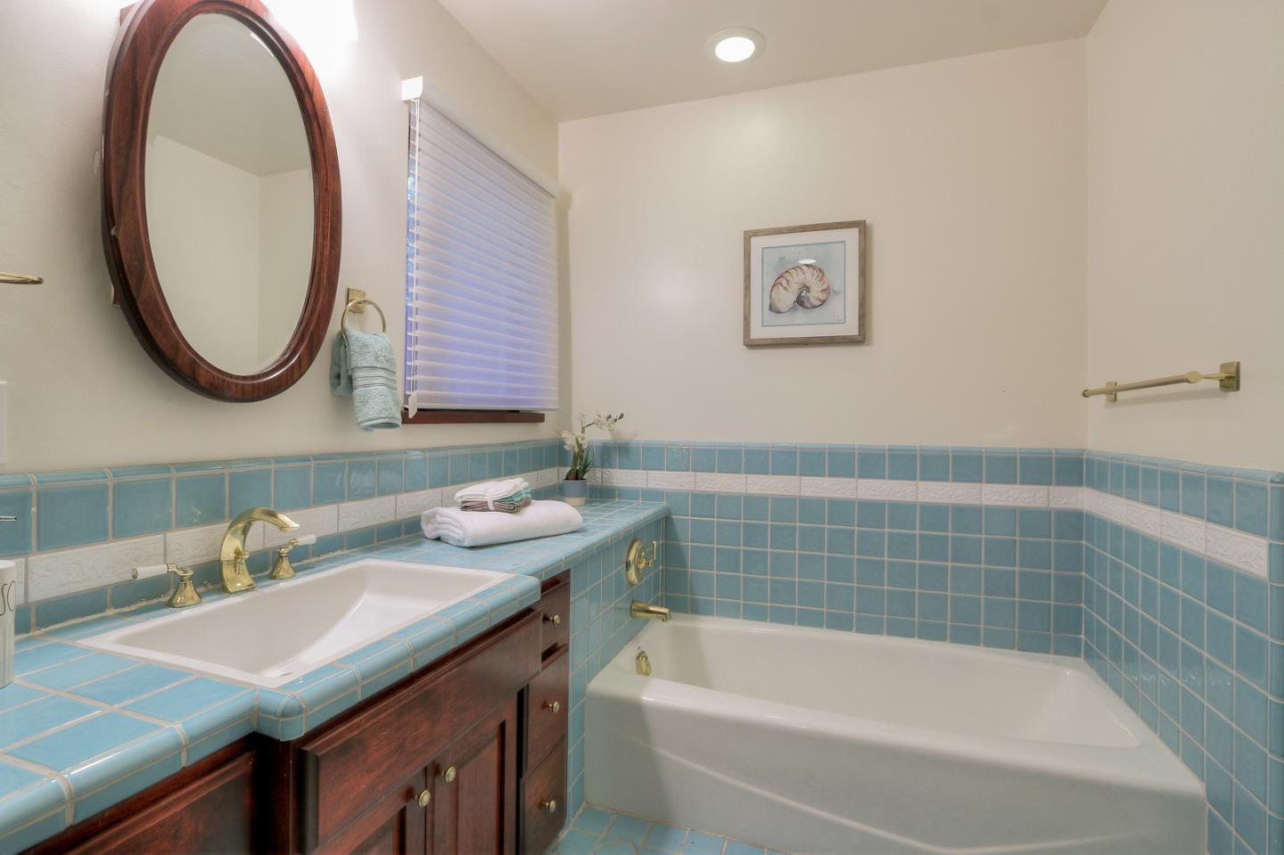 6840 Buckingham Boulevard Berkeley, CA 94705 - Photo 31 of 50 a bathroom with a tub sink and mirror