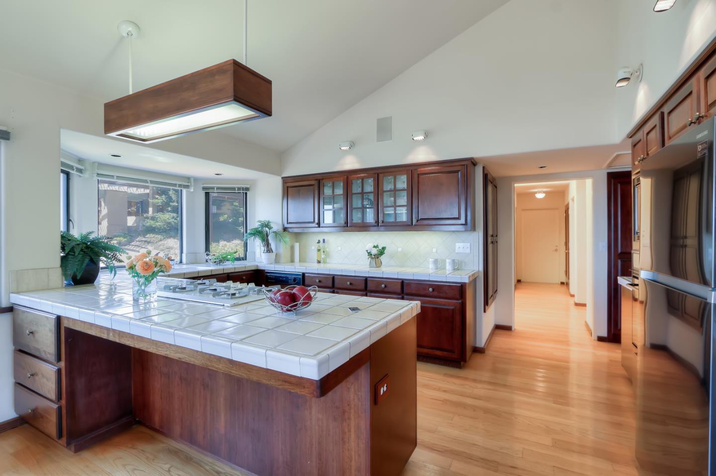 6840 Buckingham Boulevard Berkeley, CA 94705 - Photo 47 of 50 a view of a kitchen island a stove a sink dishwasher and wooden cabinets