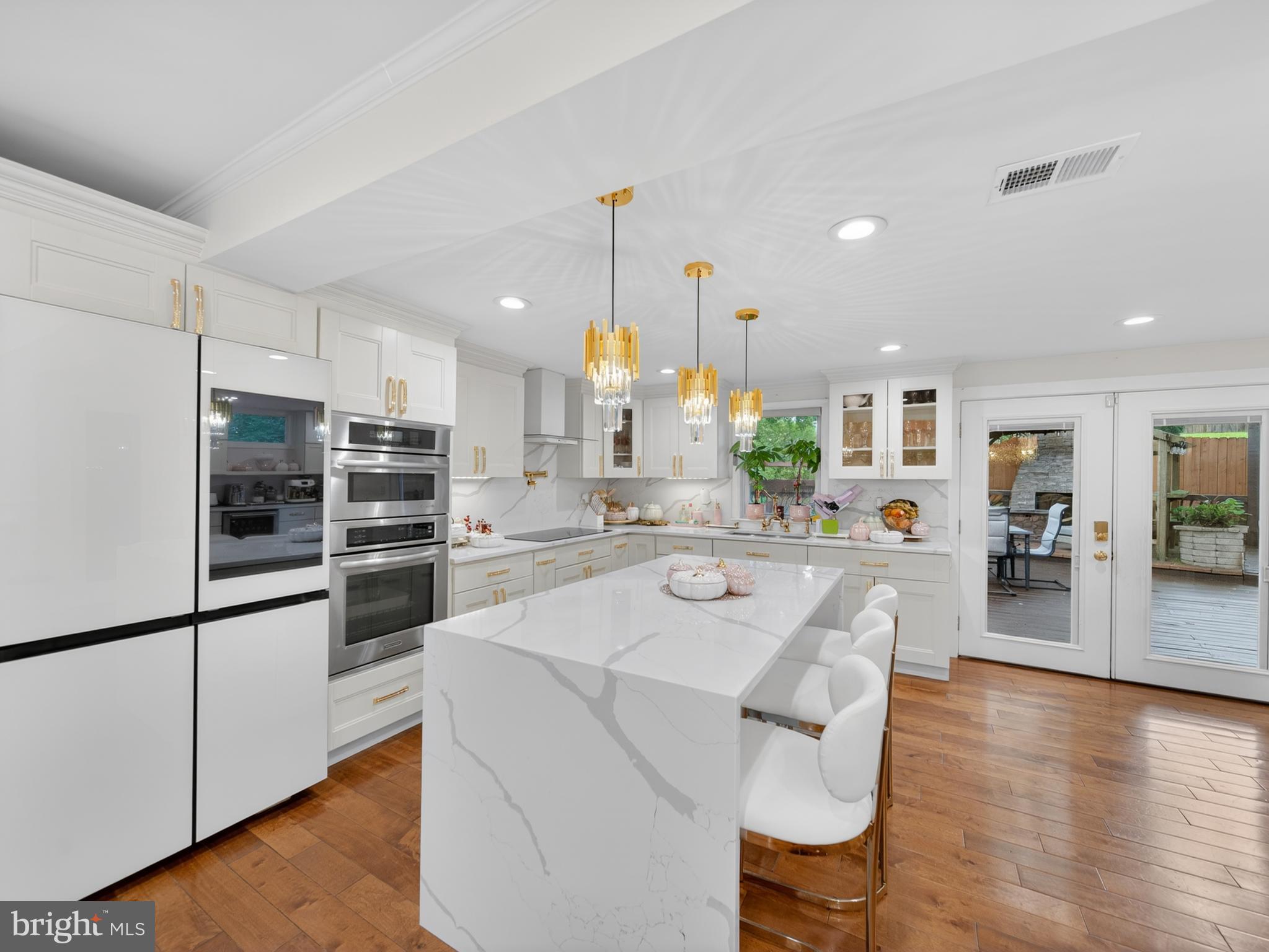 13427 Delaney Road Woodbridge, VA 22193 - Photo 27 of 57 a kitchen with stainless steel appliances kitchen island granite countertop a refrigerator a stove and white cabinets with wooden floor