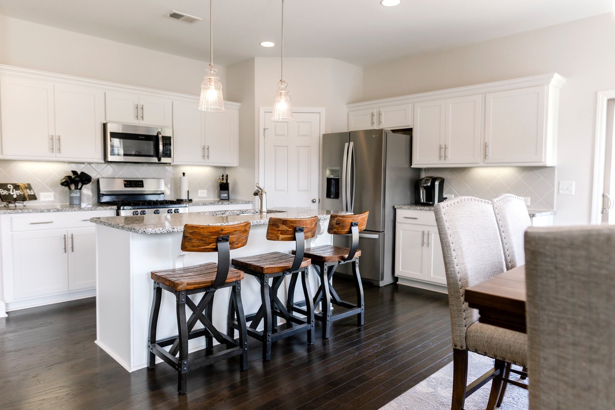 406 Quarry Road Gallatin, TN 37066 - Photo 4 of 9 a kitchen with stainless steel appliances a dining table chairs refrigerator microwave and sink