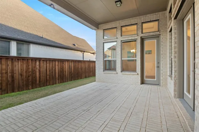 a view of a porch with wooden floor and a gate