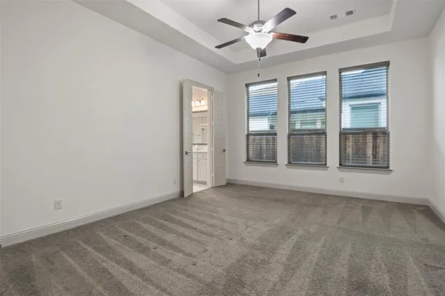 en empty room with windows and ceiling fan