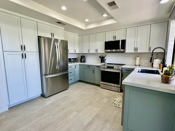 a kitchen with a refrigerator sink and wooden cabinets