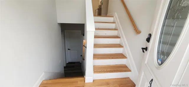 a view of staircase with wooden floor and white walls