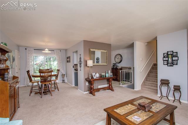4827 Del Sol Road Colorado Springs, CO 80918 - Photo 24 of 24 Beautiful and open main level floor plan that offers lots of natural light. This view is from the main level living room to include the dining area, kitchen and stairs to the upper and lower levels