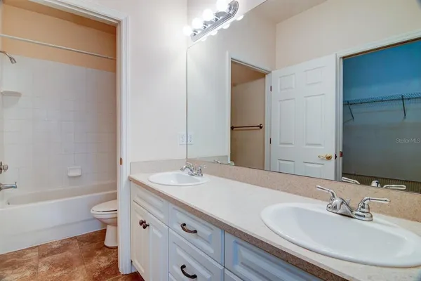 a bathroom with a granite countertop sink a toilet and shower