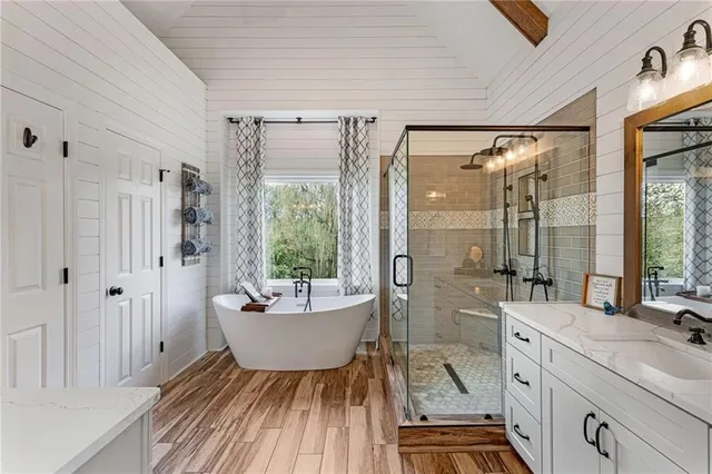a spacious bathroom with a shower a sink and a large mirror