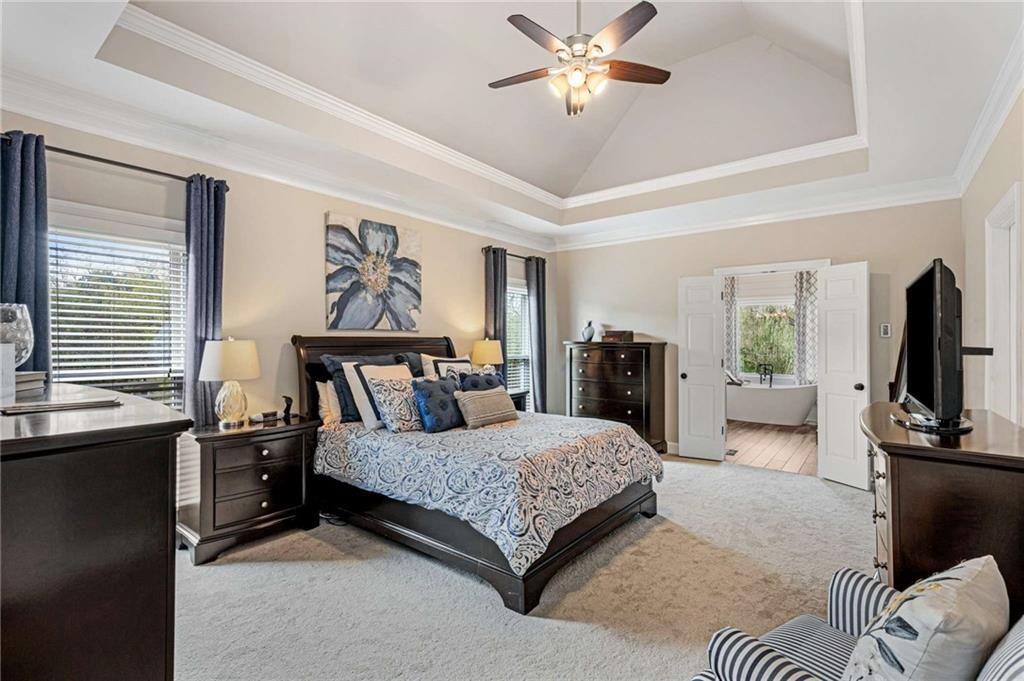 802 Clubhouse Pointe Woodstock, GA 30188 - Photo 26 of 66 a bedroom with a large bed and a chandelier