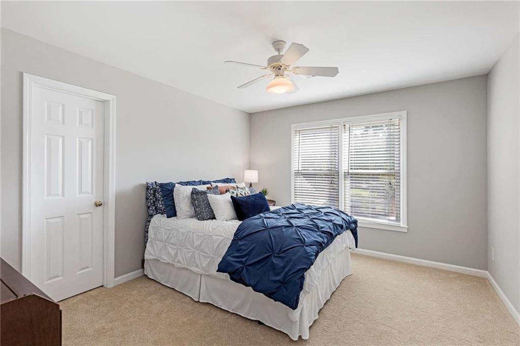 802 Clubhouse Pointe Woodstock, GA 30188 - Photo 38 of 66 a spacious bedroom with a large bed chandelier and a window