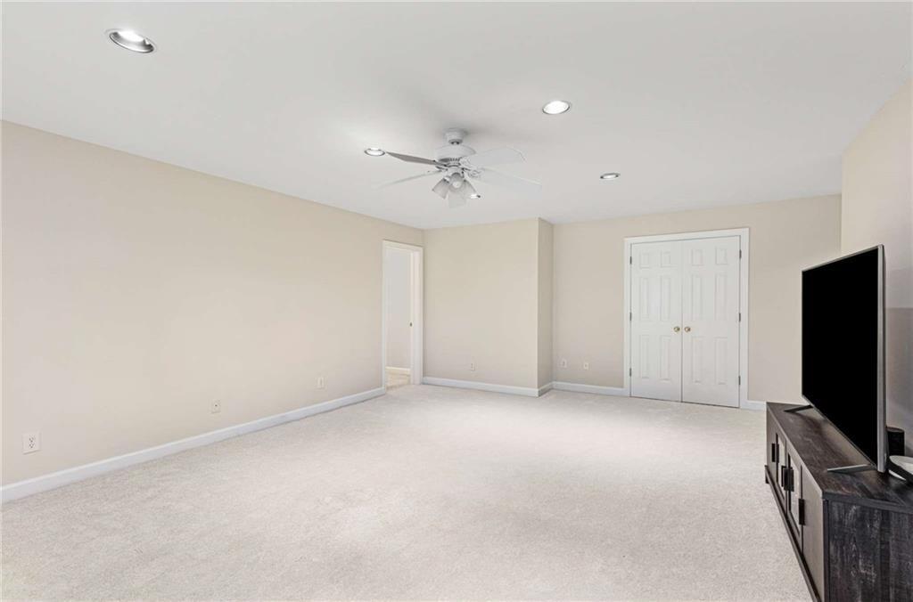 802 Clubhouse Pointe Woodstock, GA 30188 - Photo 47 of 66 an empty room with a flat screen tv and ceiling fan