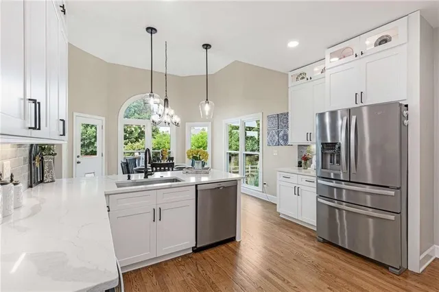 a kitchen with stainless steel appliances kitchen island granite countertop a refrigerator and a stove